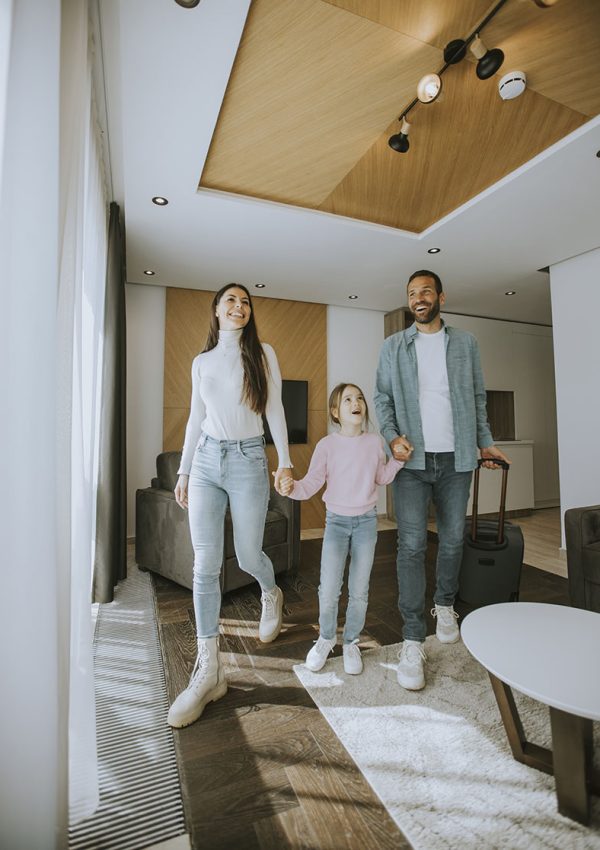 Happy young family arrive into hotel room